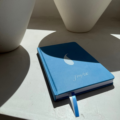 Blue notebook with a white logo on a light surface